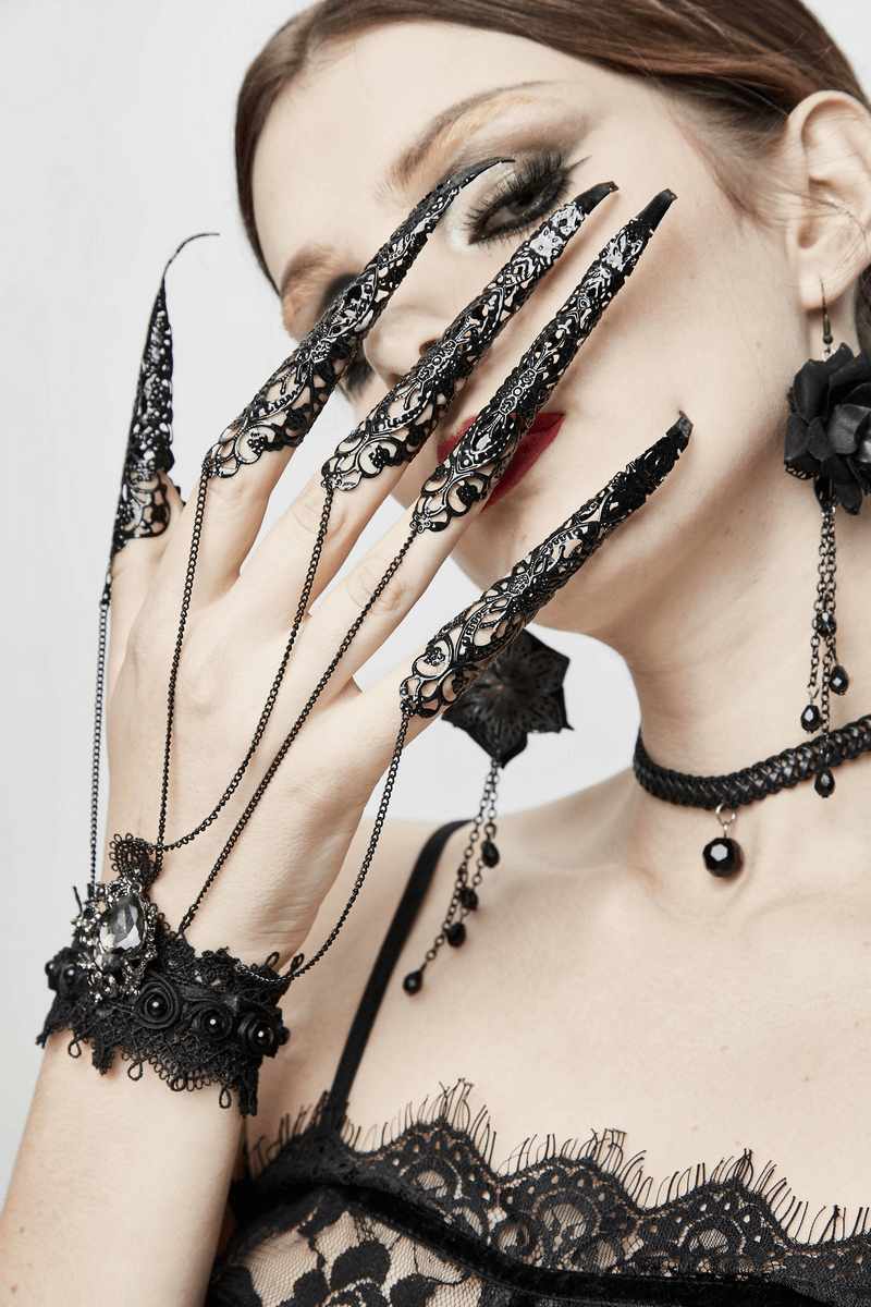 Gothic black bracelet with finger cover, styled with lace and chains on a model's hand, perfect for gothic fashion.