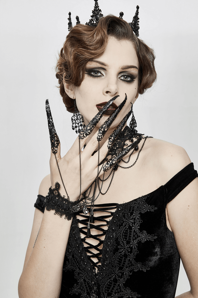 Gothic black bracelet with finger cover showcased by a fashionable model in a dark lace outfit.