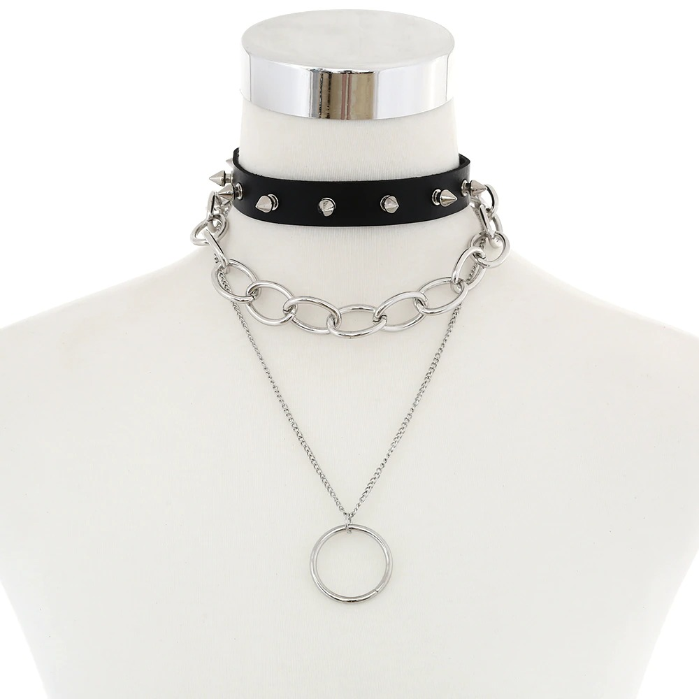 Gothic black choker necklace layered with silver chain and circular pendant, perfect for vintage and alternative styles.