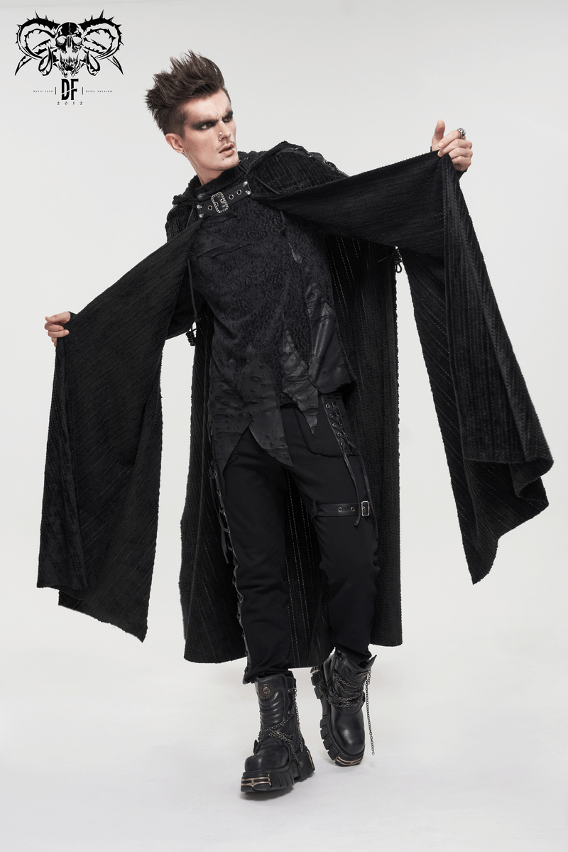Stylish man in a gothic black fleece hooded cape with buckle belt and fur collar, exuding vintage charm.