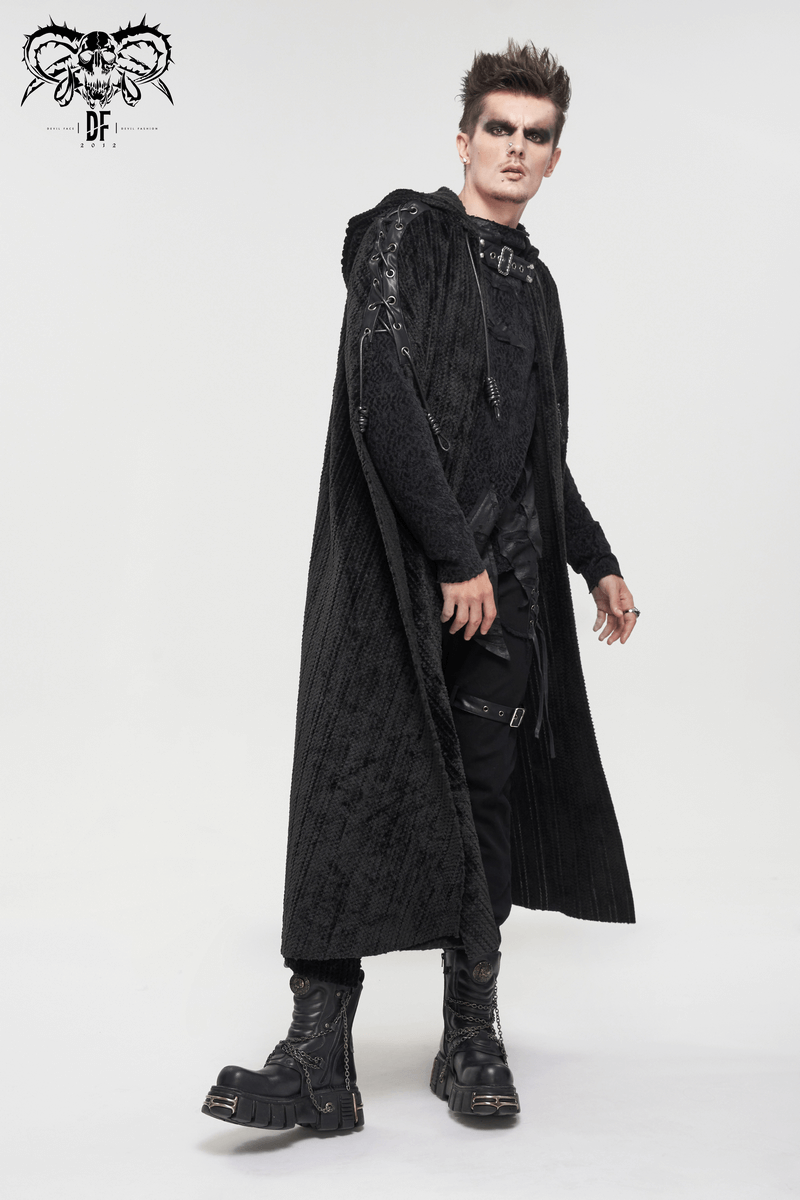 Stylish man in a gothic black fleece hooded cape with buckle belt, exuding vintage charm and edgy fashion.