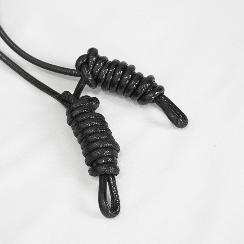 Close-up of black cord ends with spiral wraps, perfect for gothic and vintage cape designs.