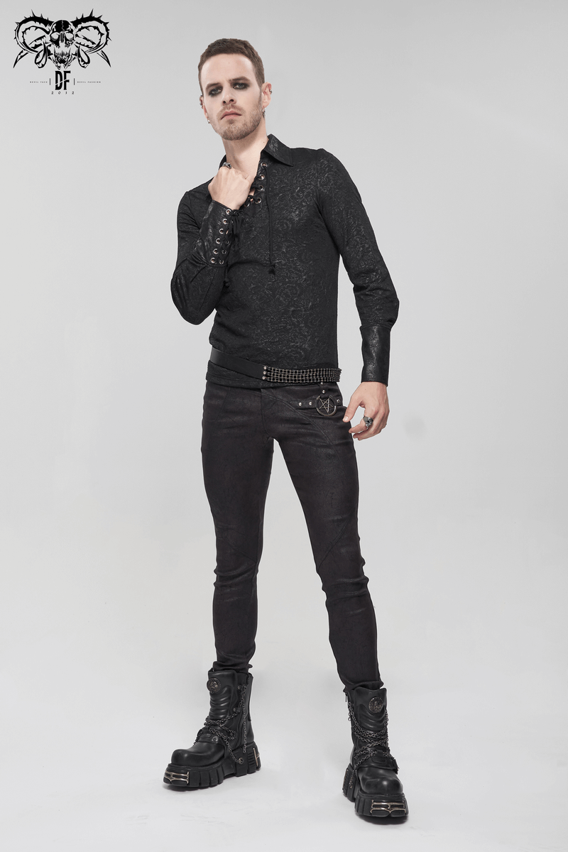 Stylish male model in gothic black pants with metal pentagram, showcasing punk fashion and edgy aesthetics.