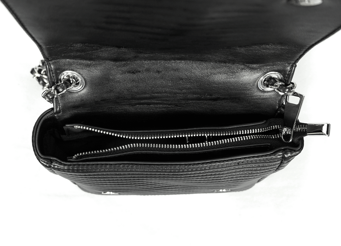 Inside view of a gothic black PU leather shoulder bag with silver rivets and zipped compartments.