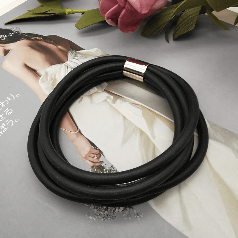 Gothic black rubber bangles for women - stylish vintage charm bracelets on elegant magazine backdrop.
