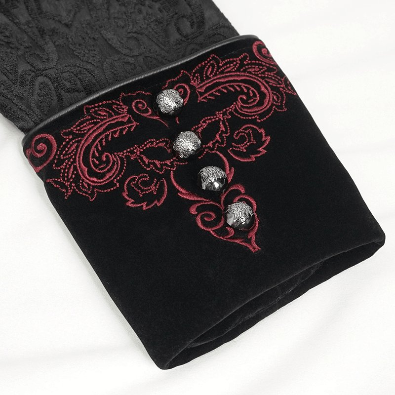 Close-up of floral embroidery and decorative buttons on a gothic black coat sleeve for women.