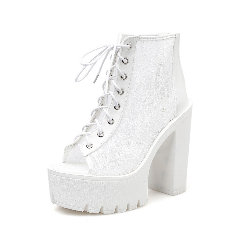 Gothic white platform ankle boots with lace detailing and high chunky heels for an alternative rock style.