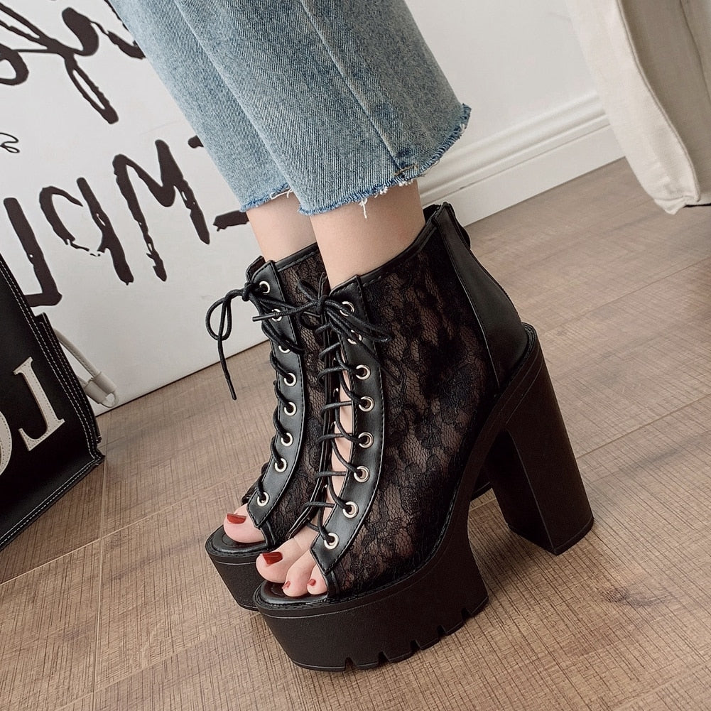 Gothic black and white platform sandals with square heels, featuring lace-up design and open toe style.