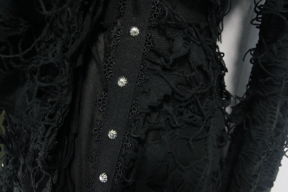 Close-up of a gothic black coat featuring intricate lace and button details, perfect for a steampunk inspired wardrobe.
