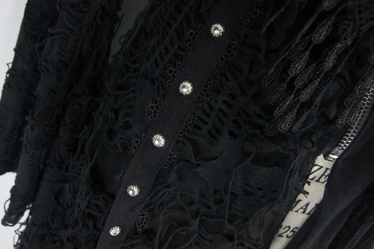 Close-up of black women's steampunk coat, featuring intricate lace details and decorative buttons for a chic gothic style.