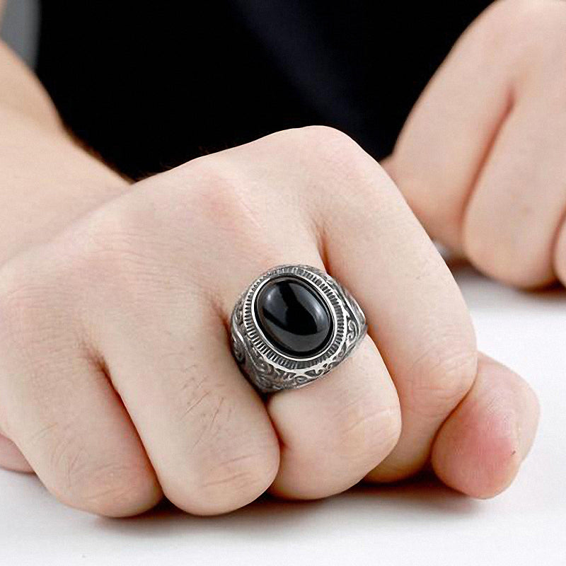 Gothic blue and black stone ring on a finger, showcasing stainless steel design and bold black stone centerpiece.