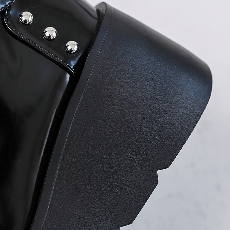 Close-up of a black gothic platform ankle boot with spikes and rivets, showcasing its edgy design.