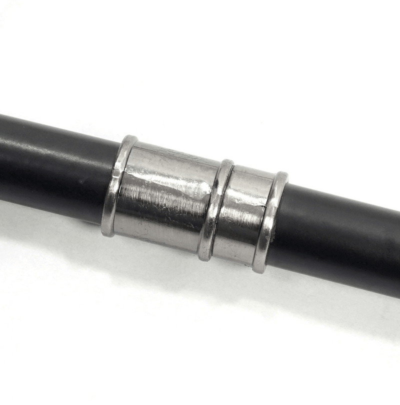 Close-up of a gothic cane with three metallic bands on a sleek black shaft, showcasing exquisite craftsmanship.