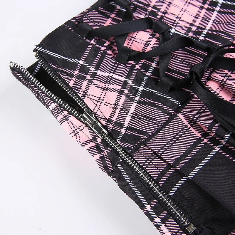 Close-up of a gothic checkered mini skirt with pink and black plaid design and lace ties for a stylish punk aesthetic.