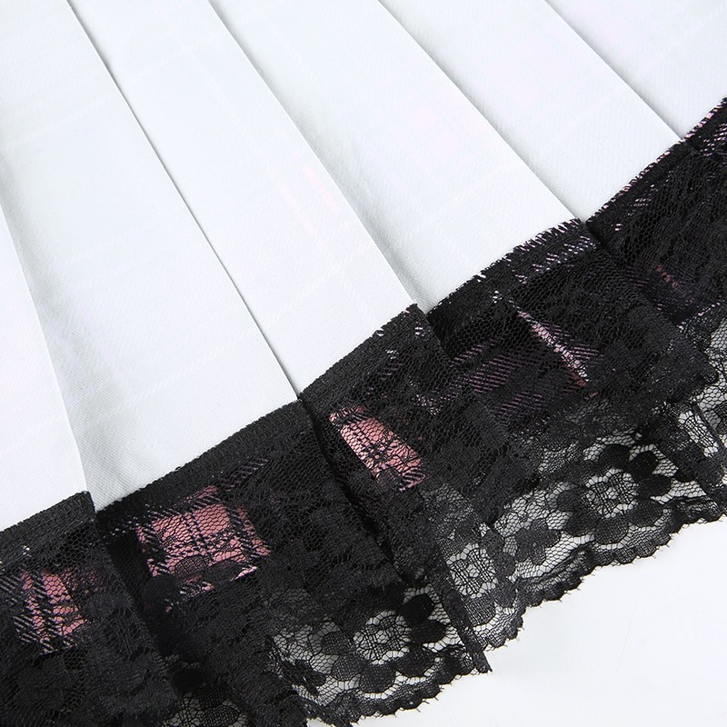 Lace-trimmed hem of a stylish gothic checkered mini skirt, showcasing delicate black lace on a white fabric.