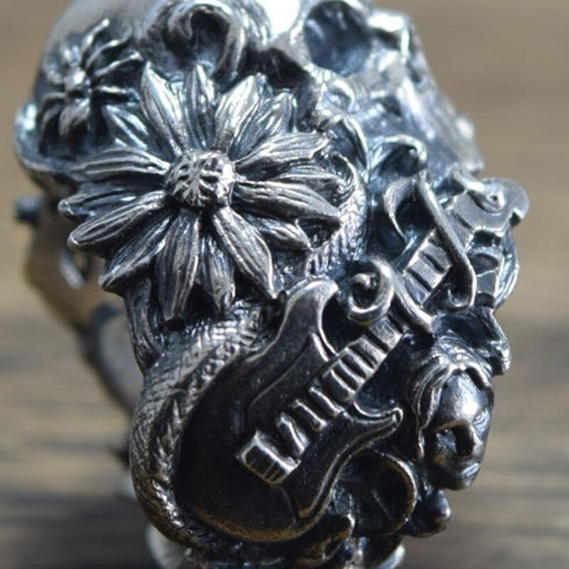 Gothic ring featuring a skull, flower, and guitar design in detailed stainless steel craftsmanship.