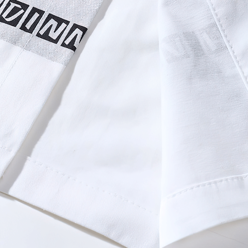 Close-up of a stylish white shirt showcasing a unique black logo design on fabric.