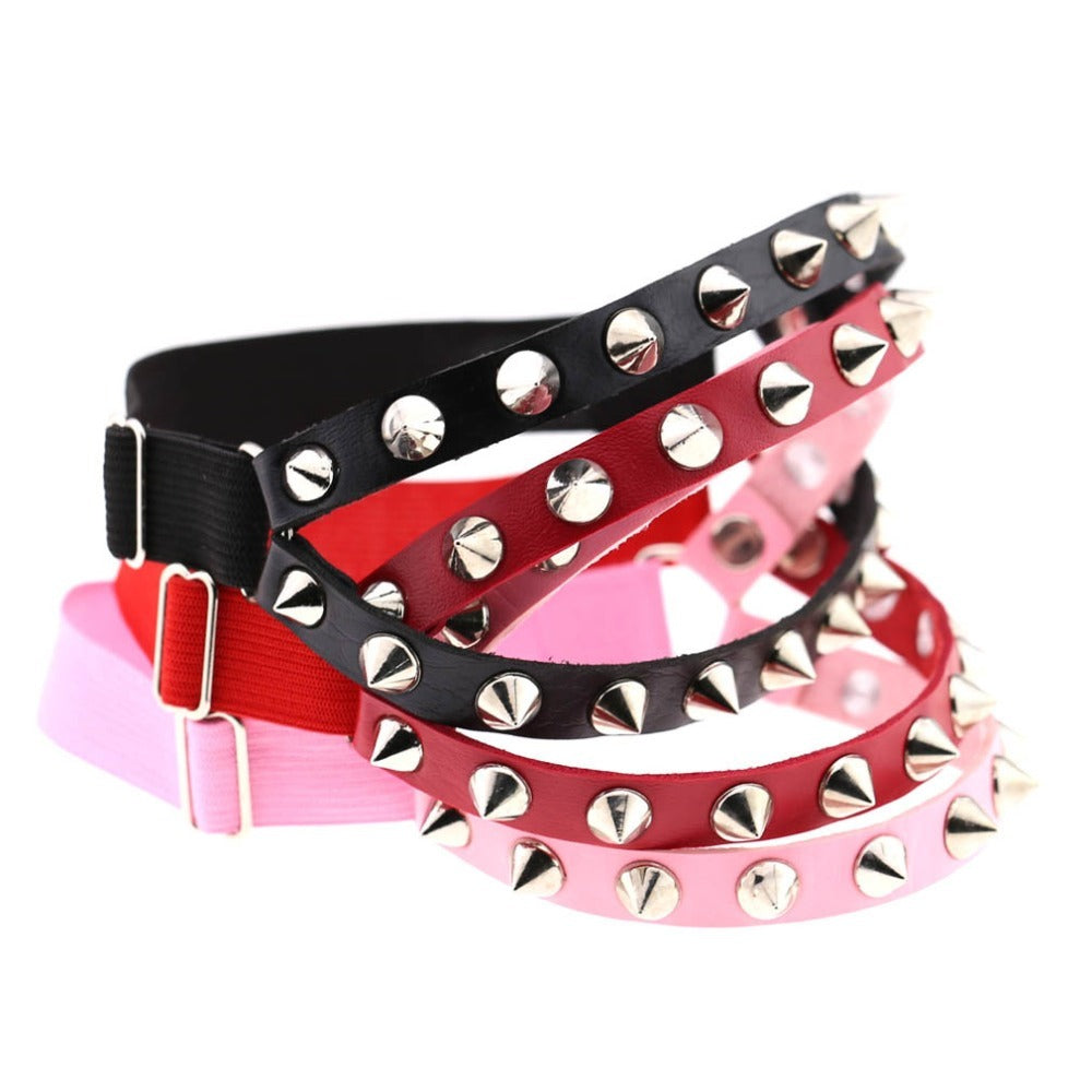 Colorful gothic elastic garter belts with spikes in black, red, and pink for cosplay or fashion accessories.