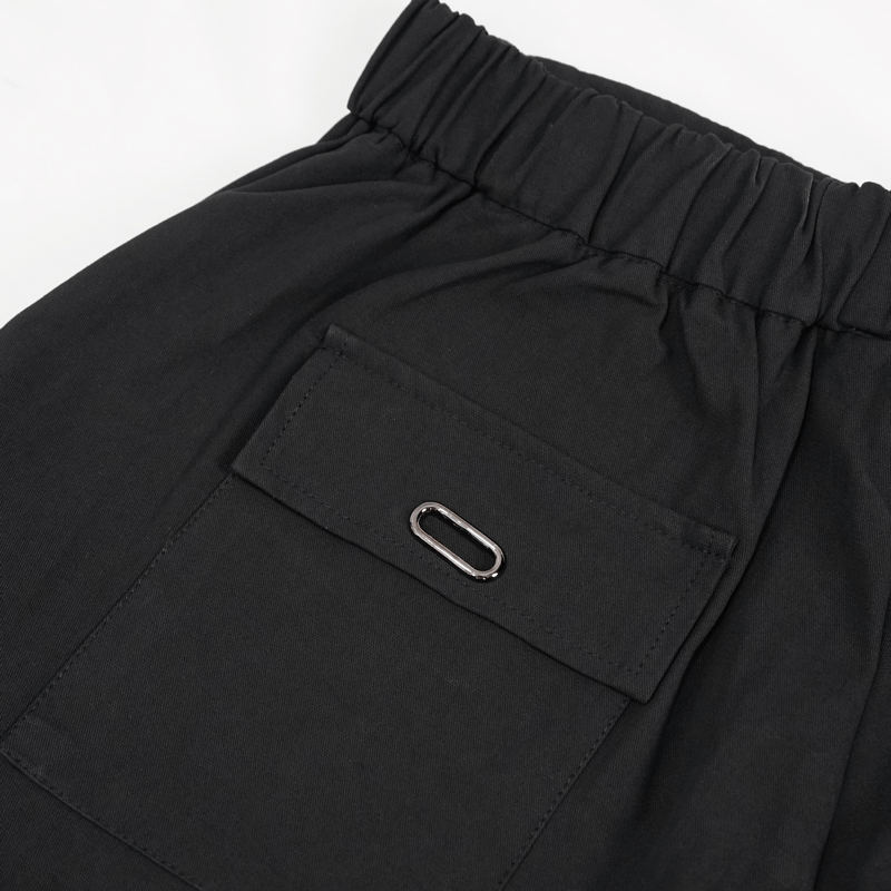Close-up of gothic elastic waistband and pocket detail on men's punk cargo pants.
