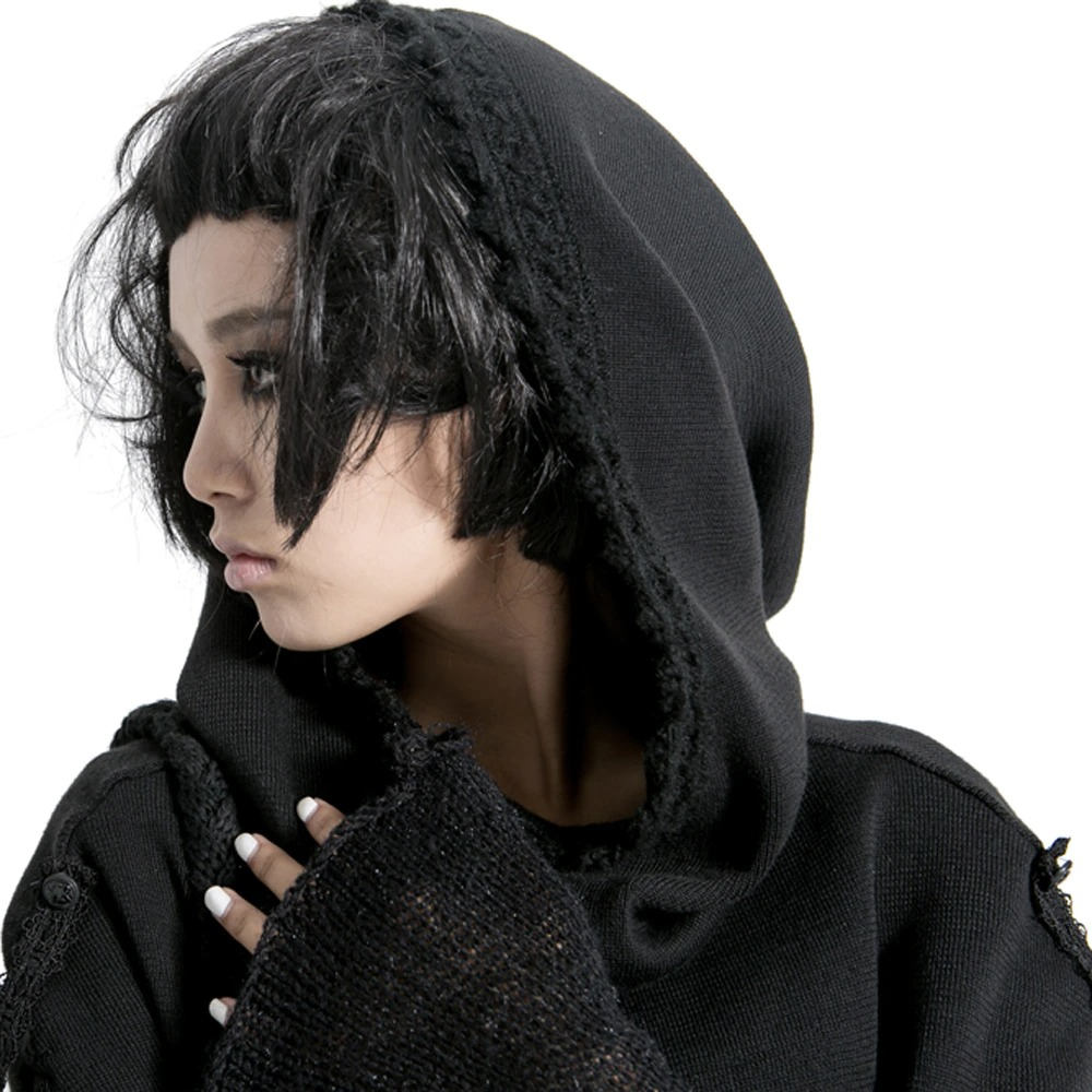 Gothic female model in a black knitted wool cape with hood, showcasing punk fashion style.