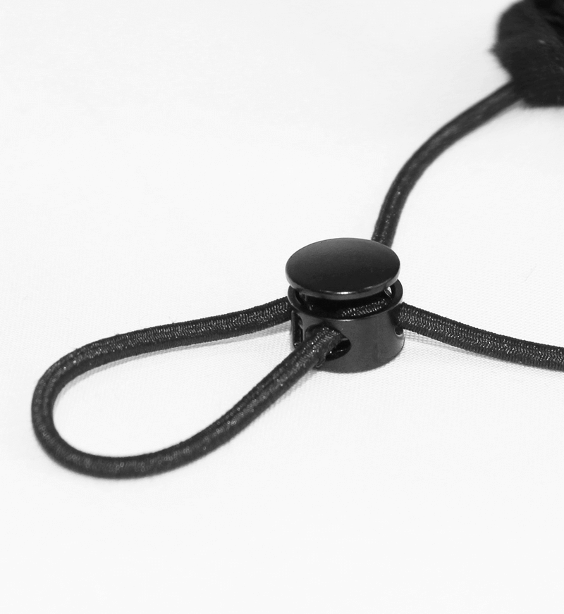 Close-up of the adjustable black cord lock for a velvet mask with a sleek design and easy fit.