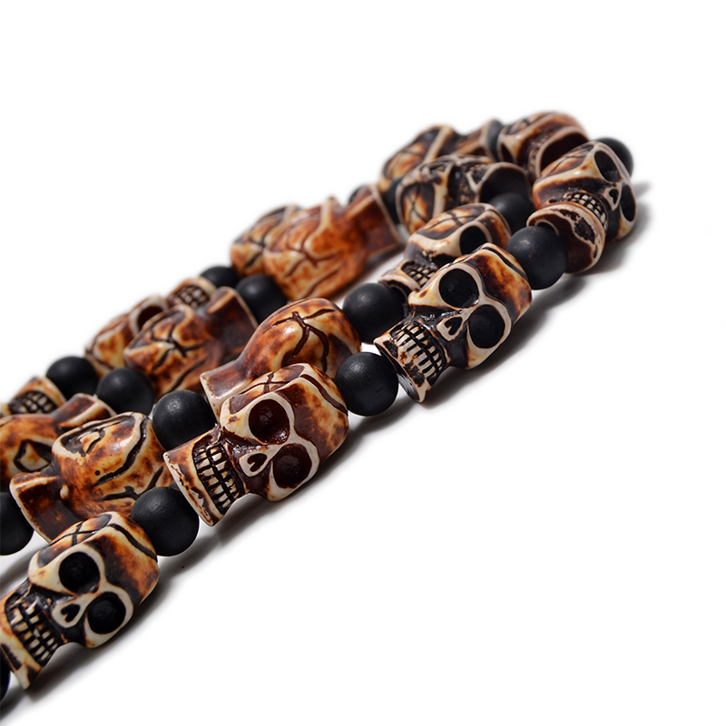 Gothic imitation bone necklace featuring skulls, perfect for cosplay or rock concerts, made of resin and black beads.