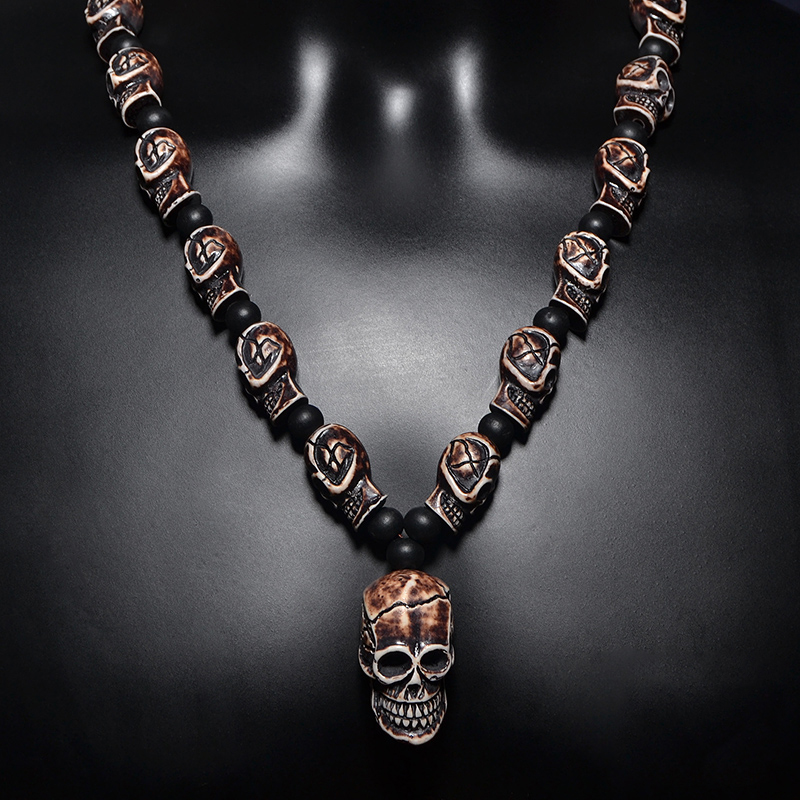Gothic imitation bone necklace featuring small skulls and a large skull pendant, perfect for men and women.