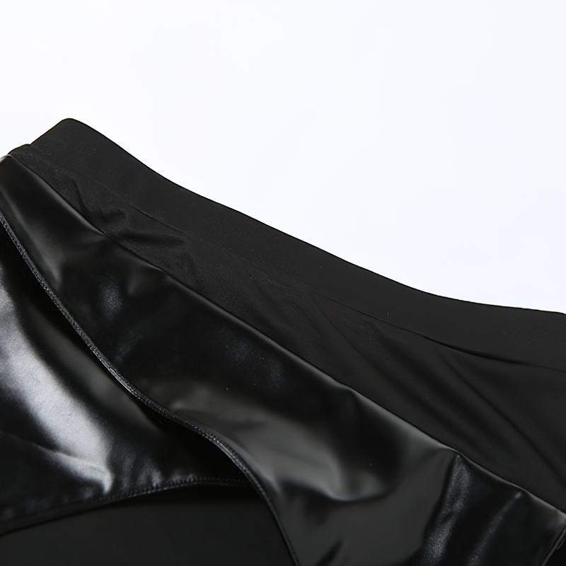 Close-up of the black patchwork irregular hem of a gothic mini skirt, showcasing its shiny fabric and stylish design.