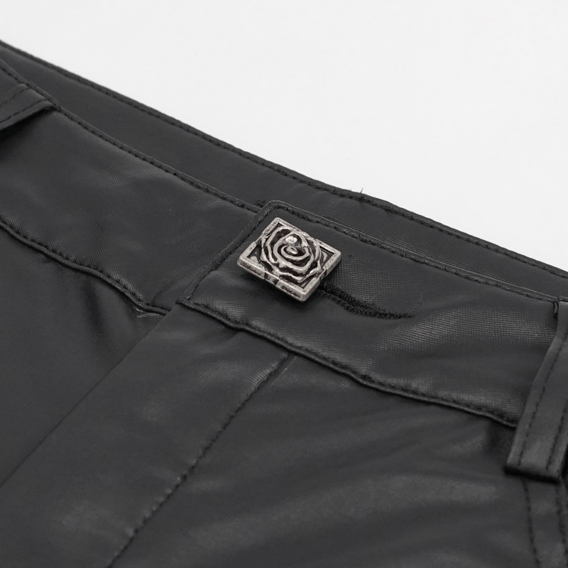 Close-up of black faux leather leggings showing intricate silver detail and applique design for a punk style.