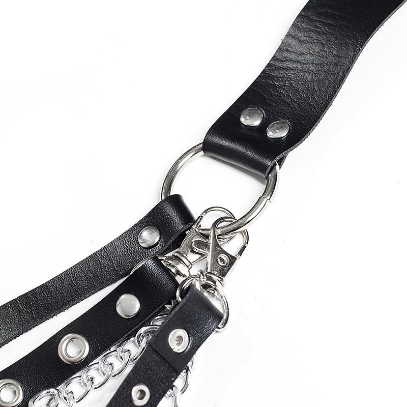 Close-up of a Gothic leather belt featuring faux leather straps, rivets, and a metal ring with chains.
