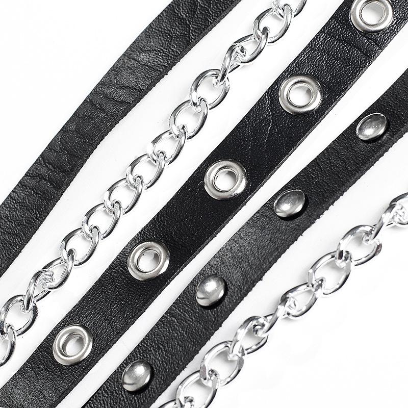 Close-up of black faux leather straps with silver chains and rivets, perfect for Gothic fashion accessories.