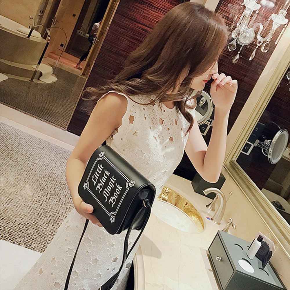 Stylish woman in white dress holding gothic letter printing shoulder bag in a chic bathroom setting.