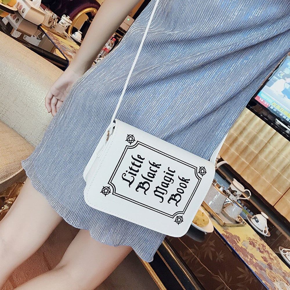 Gothic letter printed shoulder bag featuring 'Little Black Magic Book' text, perfect for alternative fashion lovers.
