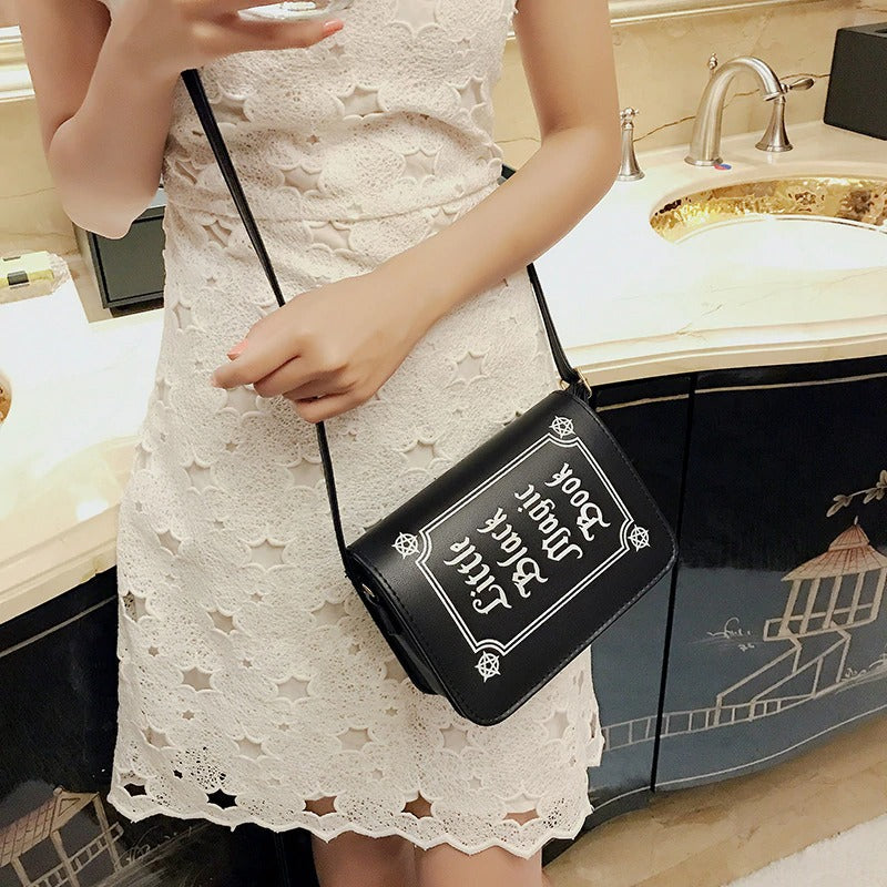 Gothic letter printing shoulder bag in black, stylishly worn as a crossbody accessory with a chic outfit.