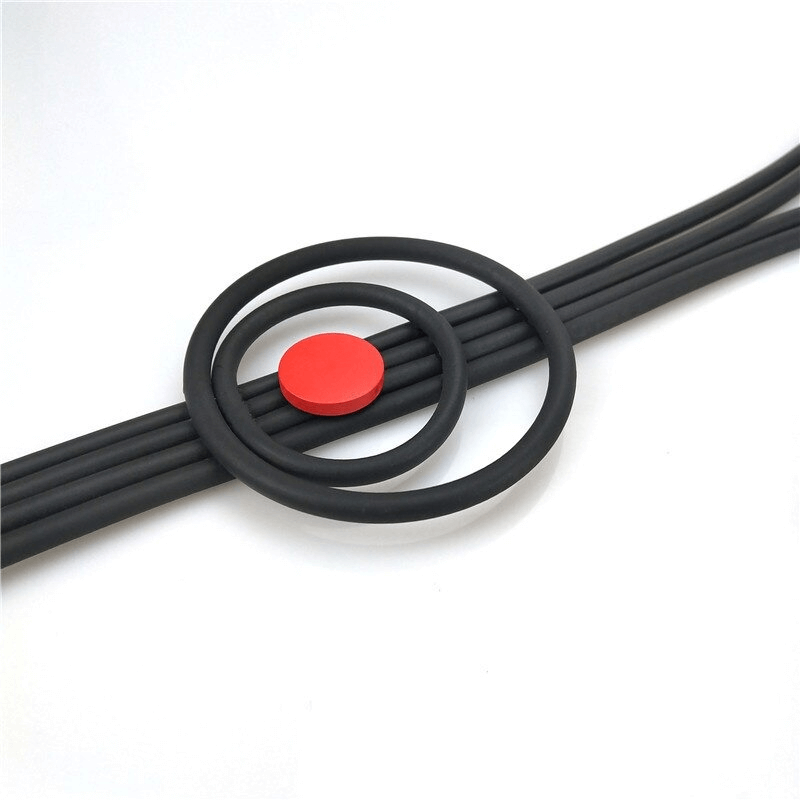 Close-up of black rubber rings and a red circle, showcasing stylish handmade accessories and trendy design elements.