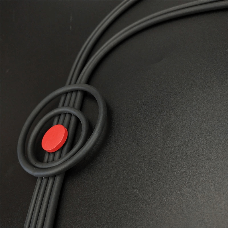 Close-up of a handmade gothic long tassel necklace featuring rubber strands and a red accent.