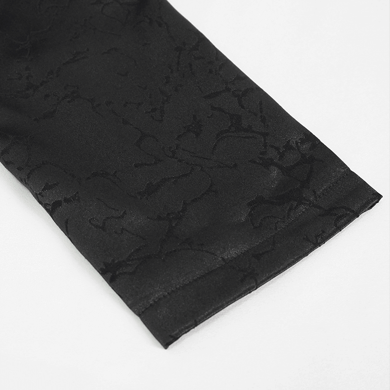 Close-up of the sleeve of a gothic black coat featuring intricate textured detailing.