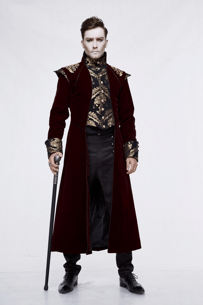 Stylish male model in vintage gothic wine coat with gold patterns, holding a cane and exuding elegance.