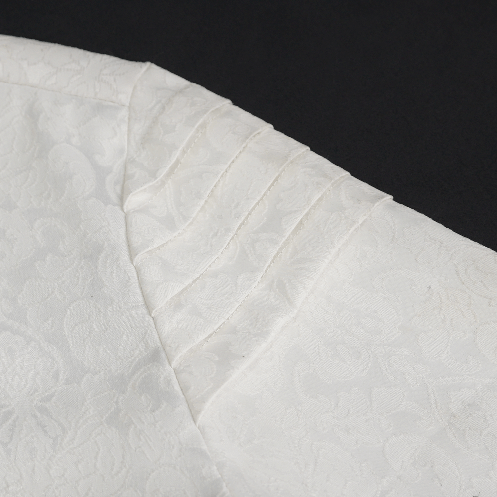 Close-up of vintage gothic men's white shirt with elegant lace frill detailed cuffs and intricate fabric texture.
