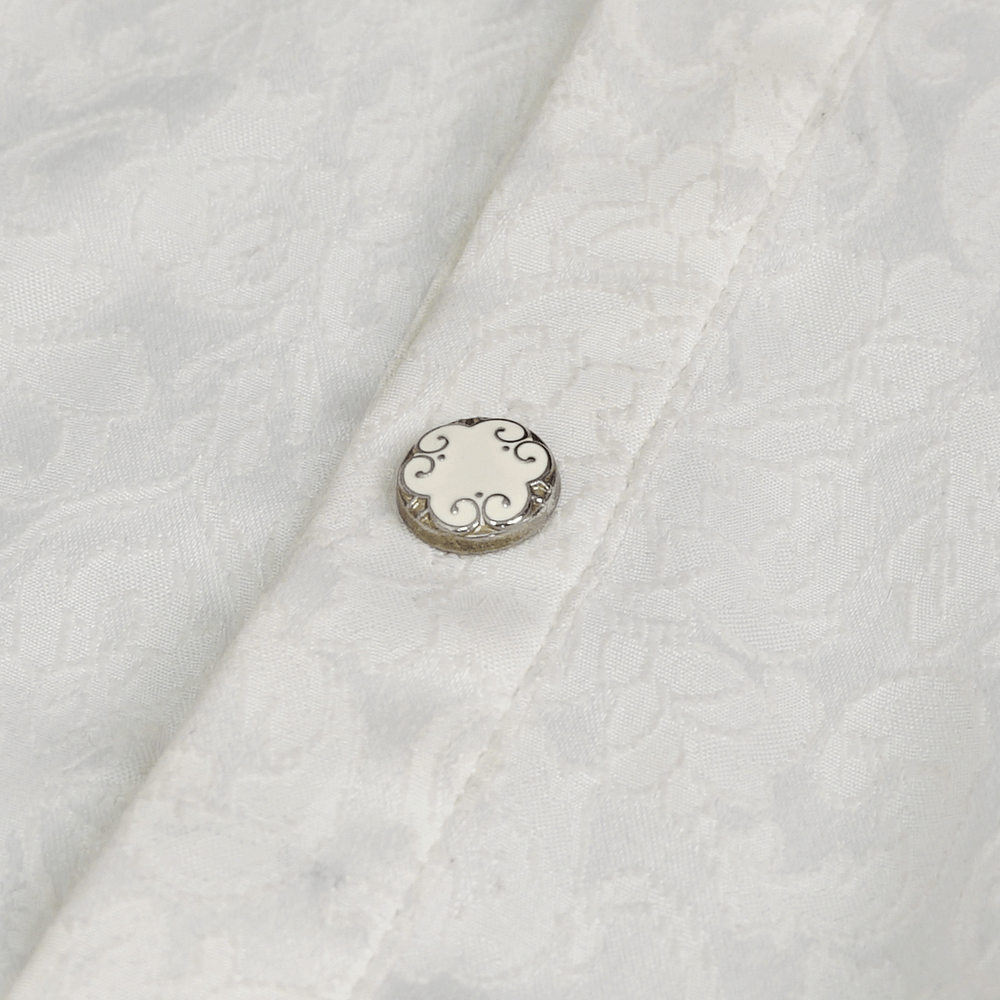 Close-up of vintage white shirt fabric with ornate metal button detail, perfect for gothic style fashion.