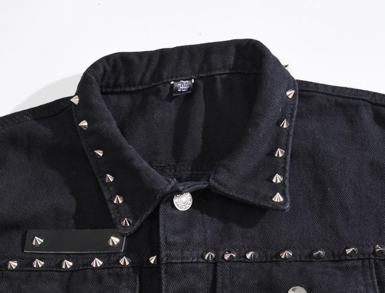 Close-up of black denim vest collar with metal rivets, showcasing gothic style and edgy design features.
