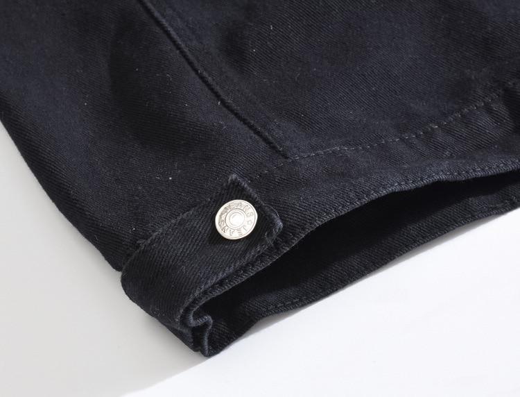 Close-up of black denim vest detail with silver rivet, showcasing gothic style and craftsmanship.