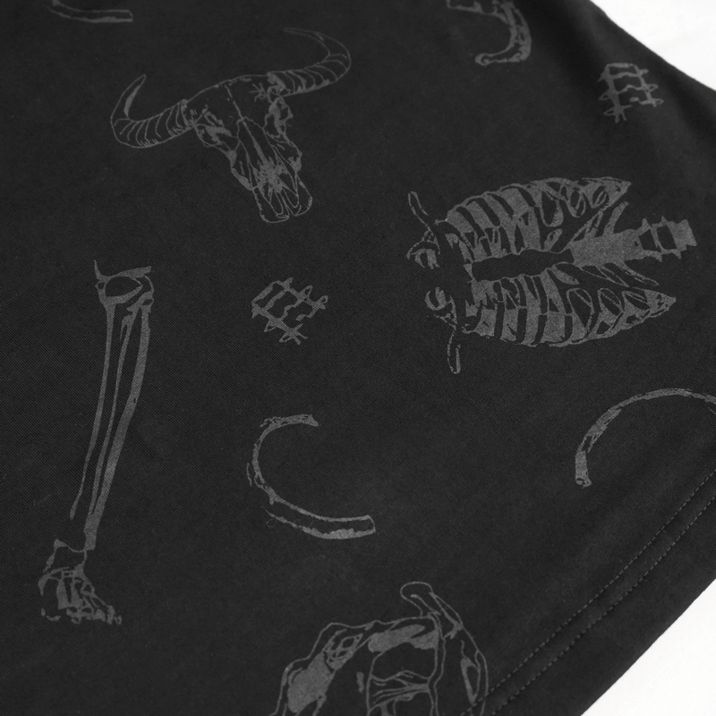 Close-up of black fabric featuring gothic skull and bone patterns, perfect for alternative fashion lovers.