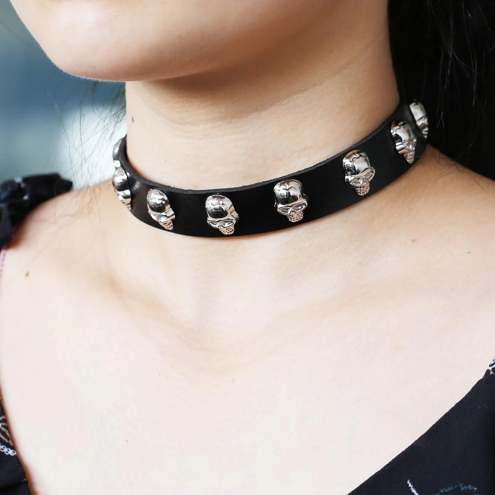 Gothic leather choker with zinc alloy skulls, perfect for alternative fashion and edgy outfits.
