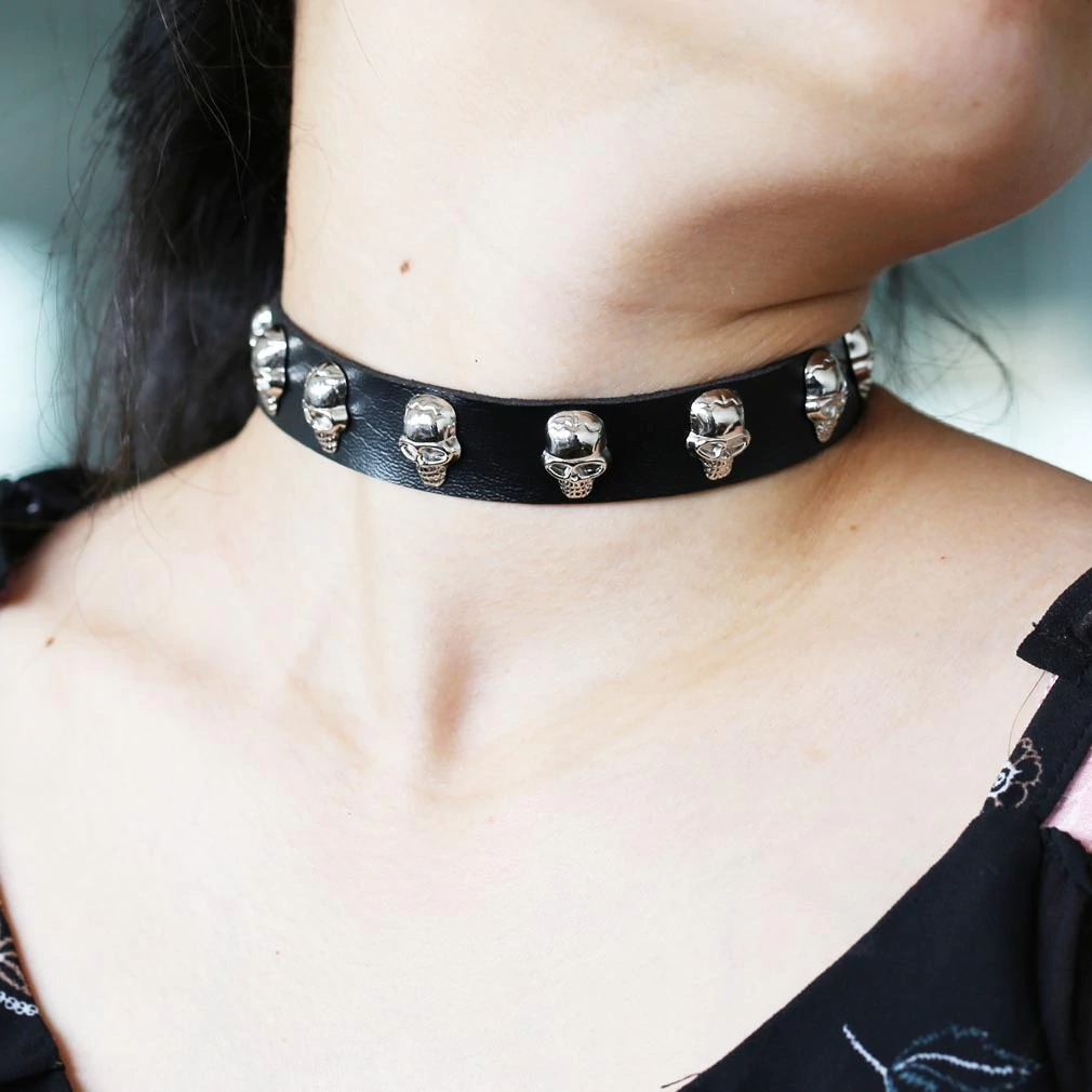 Gothic leather choker collar with silver skulls, perfect for alternative fashion and stylish outfits.