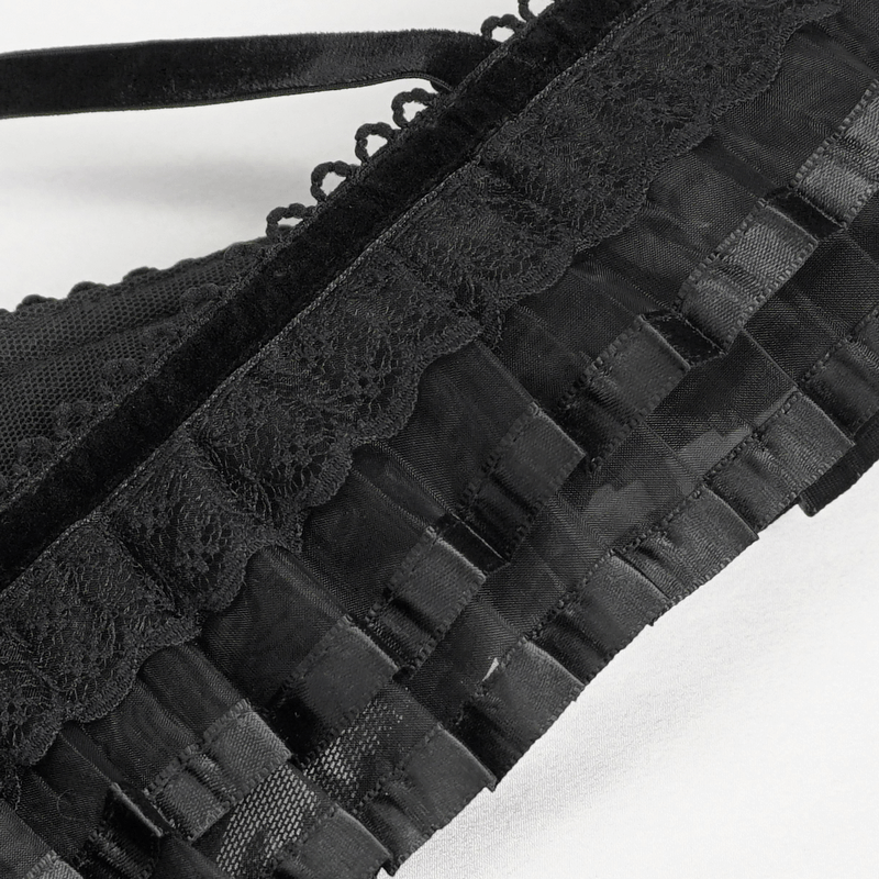 Close-up of gothic black dress ruffles, showcasing elegant lace and sleek satin detailing for a sultry style.