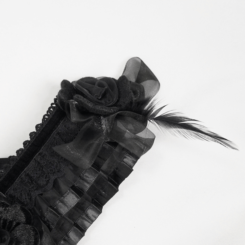 Black Gothic dress detail featuring ruffled fabric, rose embellishments, and a feather on the shoulder.