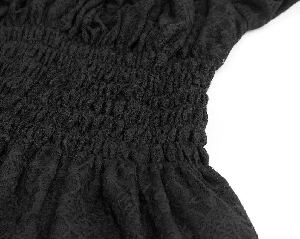 Close-up of black lace fabric showcasing the elastic waist and gathered texture of a gothic women's top.