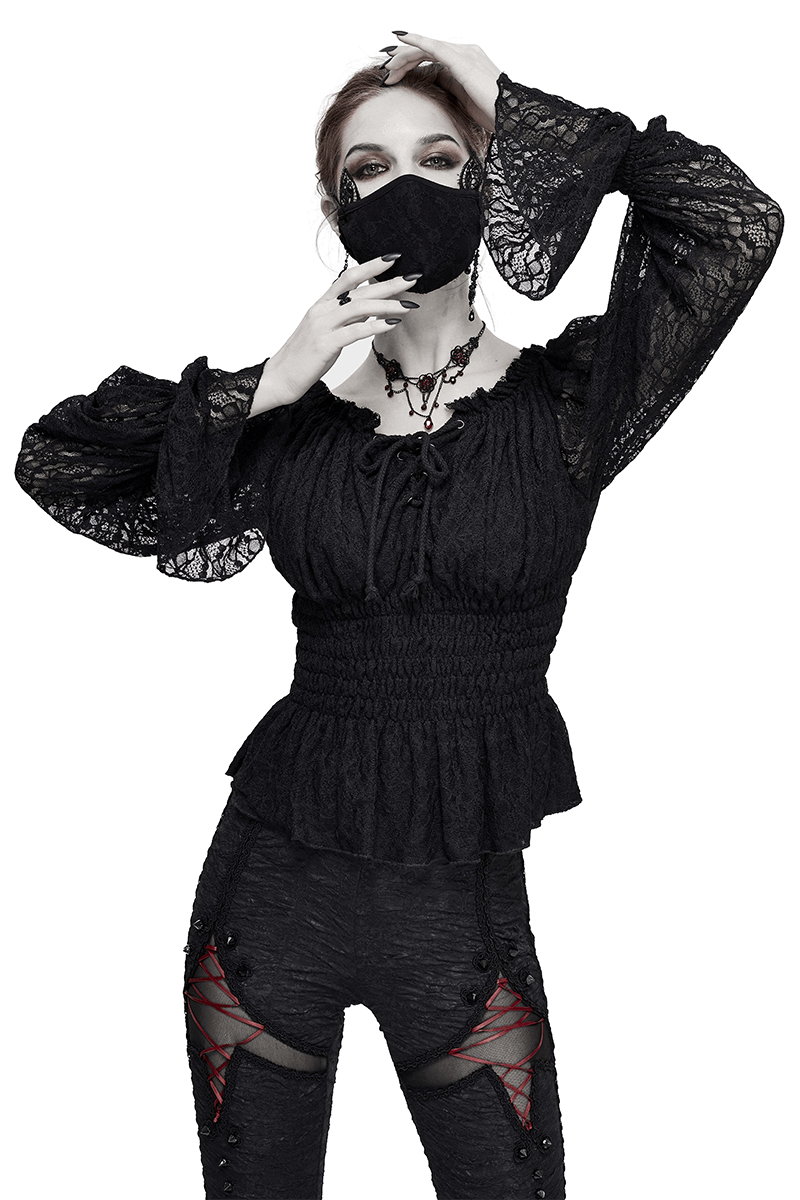 Stylish model in a gothic black off-shoulder lace top with strappy sleeves and a matching mask.