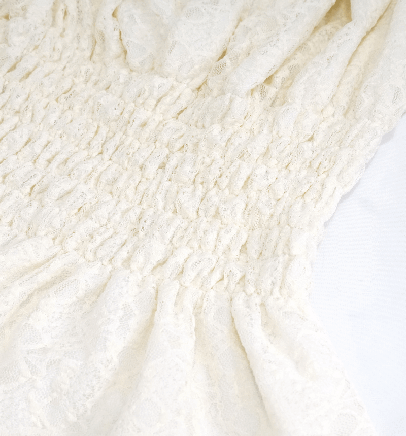 Close-up of vintage beige lace top with smocked detailing, perfect for gothic fashion enthusiasts.